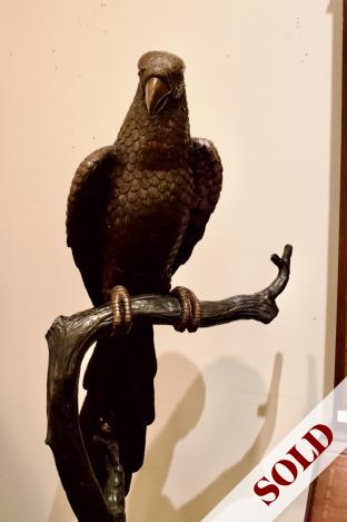 Large bronze sculpture of bird on branch