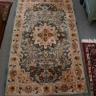 Green, gold, off white animal & foliage knotted wool rug